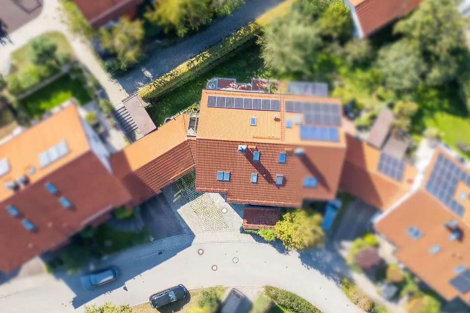 Drohnenaufnahme von oben auf die Doppelhaushälfte mit Ziegeldach, Solarmodulen und Garten