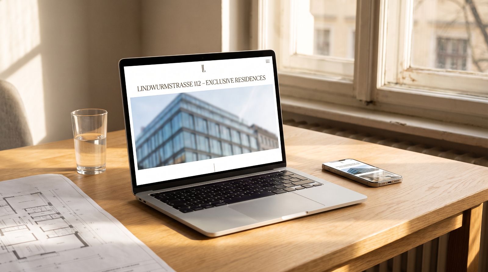 Projektwebsite auf Laptop und Smartphone neben einem Grundrissplan